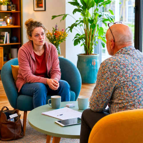Vrouw bespreekt verslaving en vastlopend gedrag tijdens een coachingsgesprek