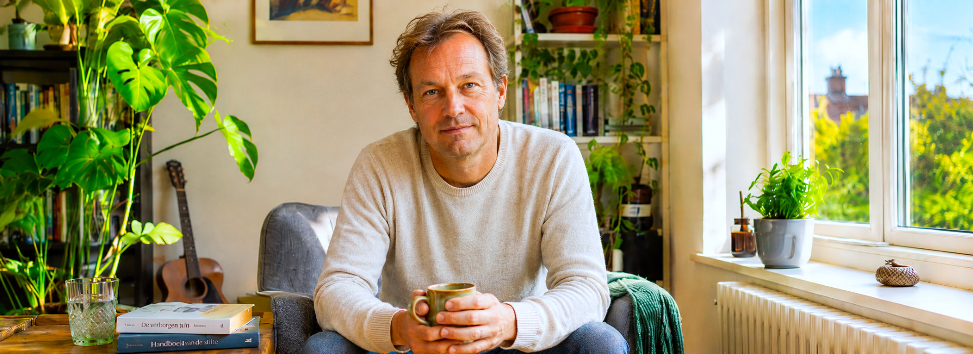 Man met koffie in lichte gespreksruimte bij coaching over levensvragen