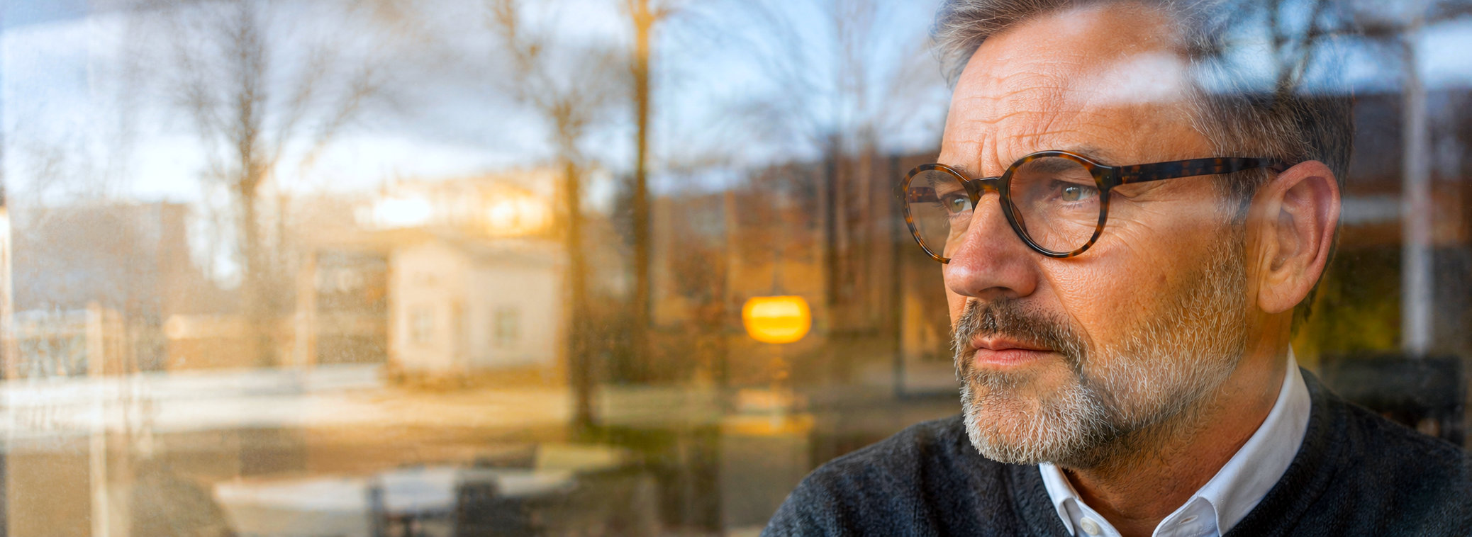 Man kijkt gespannen naar buiten, als beeld van angst en innerlijke onrust binnen de coaching en psychologische begeleiding van Spreek met Freek.