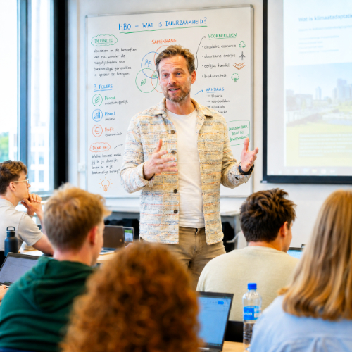 Trainer geeft uitleg aan een groep deelnemers, als beeld bij WerkPlezier binnen organisatiecoaching van Spreek met Freek.