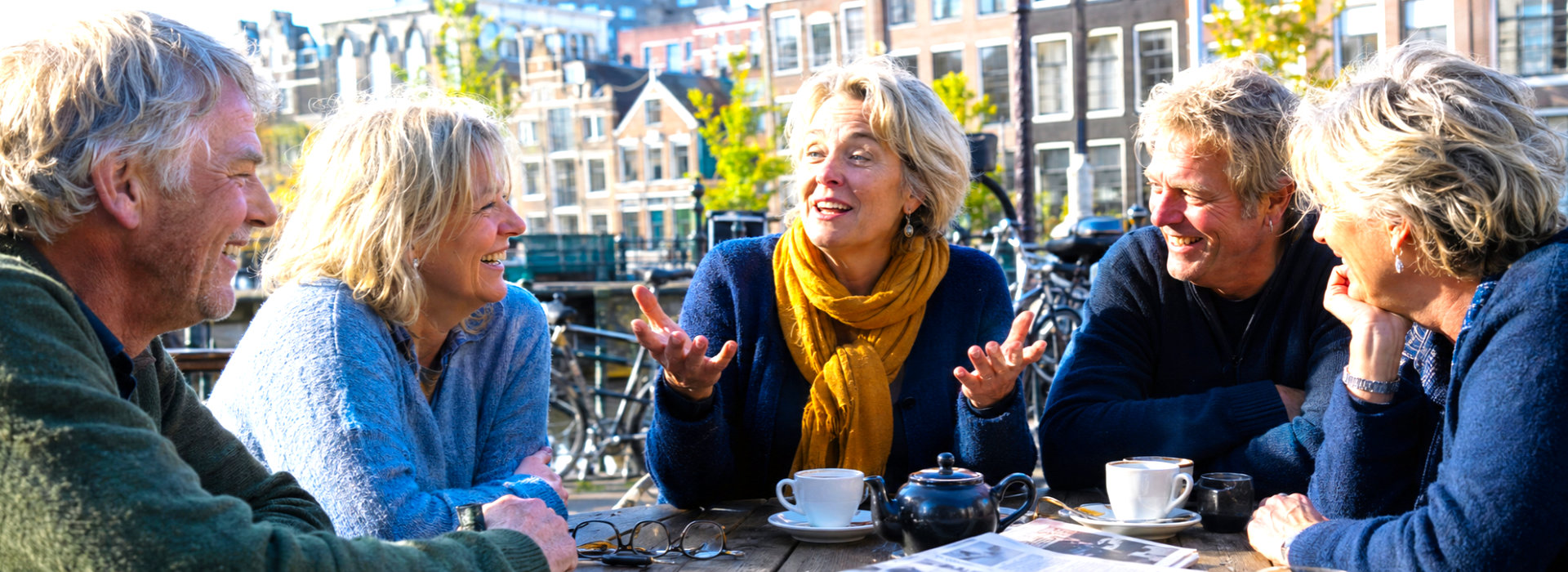 Mensen voeren samen een open en levendig gesprek, als beeld van persoonlijke groei en verbinding bij Spreek met Freek.
