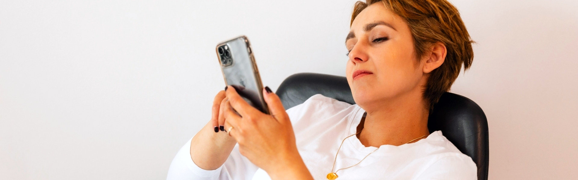 Vrouw houdt ontspannen haar smartphone voor zich tijdens een videogesprek, beeld bij online coaching vanuit huis met Spreek met Freek.