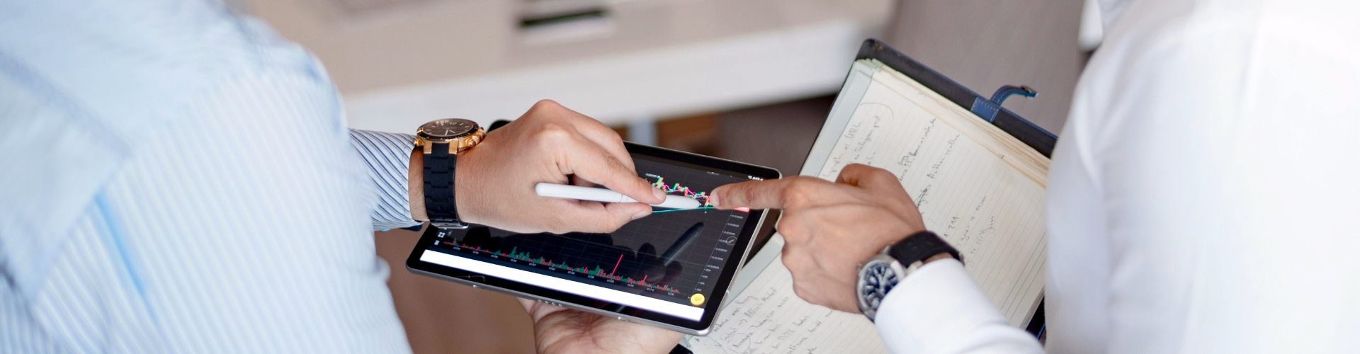 Twee mensen analyseren samen informatie op een tablet, beeld bij organisatiecoaching rond samenwerking, structuur en verandering bij Spreek met Freek.