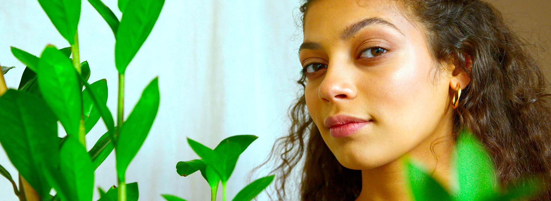 Vrouw tussen groene planten als beeld van persoonlijke groei bij Spreek met Freek.